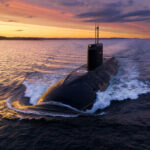 Submarine sailing at sunset in the ocean.