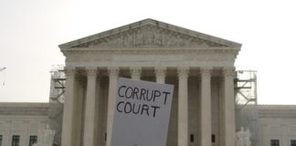 Protesters holding signs in front of the Supreme Court building