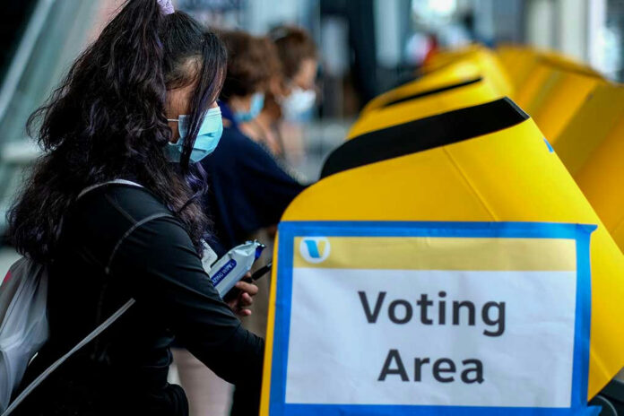 1840091617 People voting at a polling station.