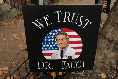 yard sign with a portrait of a man in a lab coat before a U.S. flag