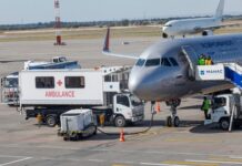Airport Showdown LOOMS — Lines Could Explode… An airplane at an airport with an ambulance and ground crew nearby