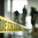 Dead American Diplomat Triggers Homicide Probe Crime scene tape with people in the background.