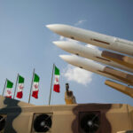 UNCONDITIONAL SURRENDER? Leaks Tell A Different Story Missiles on launchers beside Iranian flags.