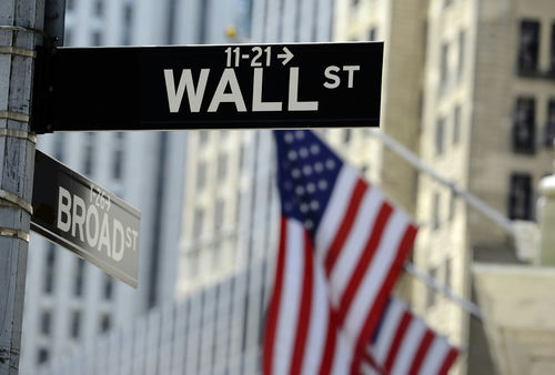 shutterstock306271739jpg Wall Street sign with American flag in background