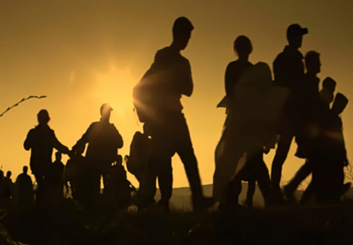 Silhouettes of people walking at sunset