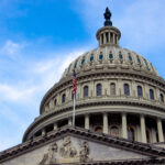 View of the U.S. Capitol building dome against a blue sky