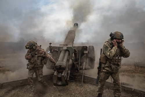 Donetsk,Reg.,,Ukraine,-,Mar.,21,,2023:,War,Of,Russia Soldiers operating a cannon in a smoky battlefield