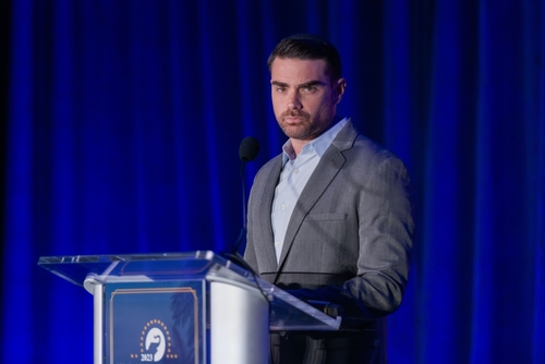 Orlando,,Us,-,Sep,15,,2023:,Ben,Shapiro,Speaking,At A man in a gray suit speaking at a podium with a microphone