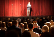 Self-Control Crisis: Training Beats Preaching Audience watching a speaker on stage in a theater