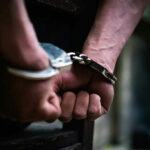 Hands in handcuffs behind back.