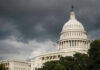 Bipartisan Housing Breakthrough Hits Trump Wall U.S. Capitol Building with dark stormy clouds above.