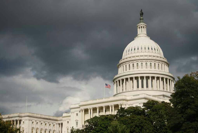 1895694736 U.S. Capitol Building with dark stormy clouds above.