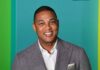 Media Star Labels MAGA Nazis — With a Catch smiling man in gray suit against teal background
