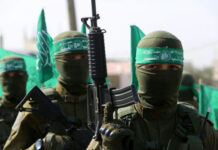 Beirut Erupts—What’s Hezbollah Really Planning? Militants in uniforms and masks holding green flags and guns.