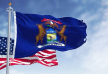 Michigan Meltdown Threatens Dem Hopes United States and Michigan flags waving against blue sky.
