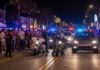 Police officers managing a crowd on a busy street at night