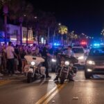 Police officers managing a crowd on a busy street at night