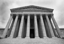 Supreme Court building with columns and ornate inscription.