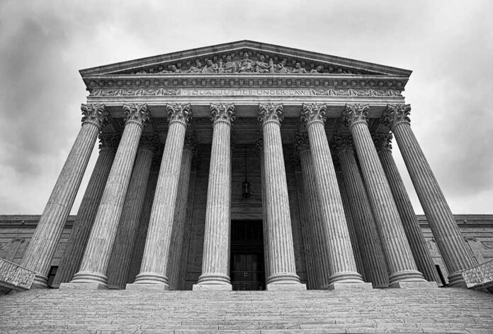 Supreme Court building with columns and ornate inscription.