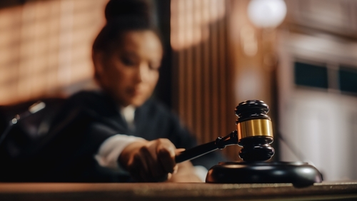 Judge striking gavel in courtroom.