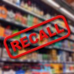 "Recall sign over blurred grocery store shelves."